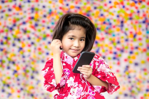 sorriso ragazza asiatica con auricolare e telefono cellulare