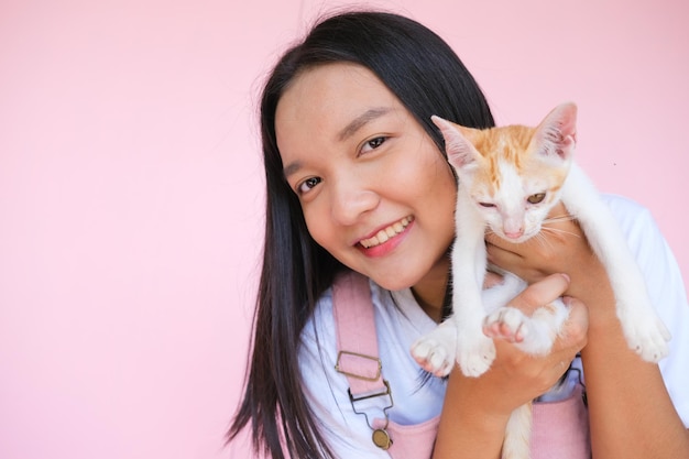 Sorriso ragazza con gatto su sfondo rosa