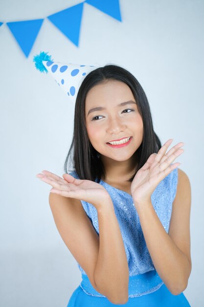 Sorriso ragazza indossare abito blu e un cappello da festa su sfondo bianco