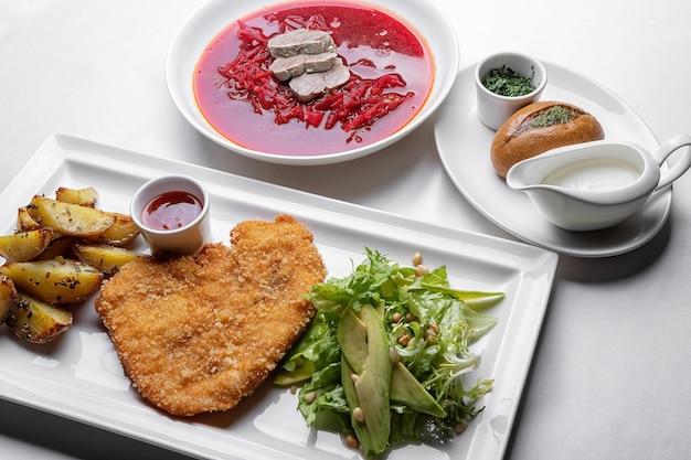 Sostanzioso pasto dell'Europa orientale Schnitzel di manzo Borscht rosso e lati