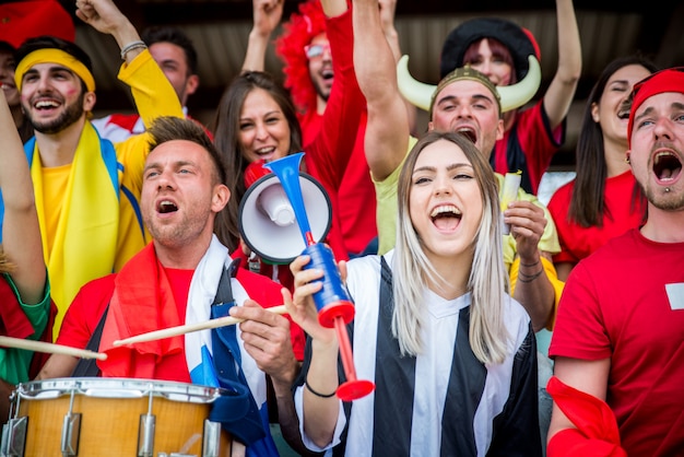 Sostenitori di calcio allo stadio - I tifosi si divertono e guardano la partita di calcio