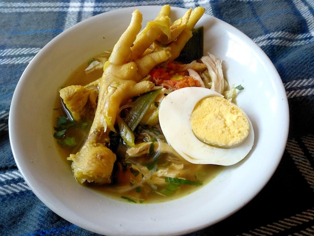 Soto Ceker Ayam Kuah Kuning o Soto piedi di pollo su una ciotola cibo culinario indonesiano