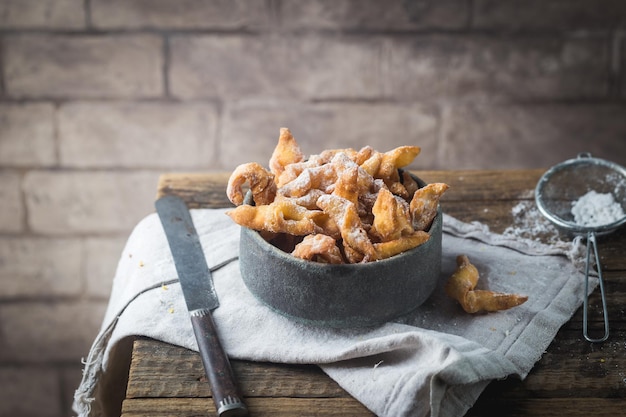 Sottobosco - biscotti tradizionali russi con zucchero a velo. Piatto con hvorost su tavola di legno