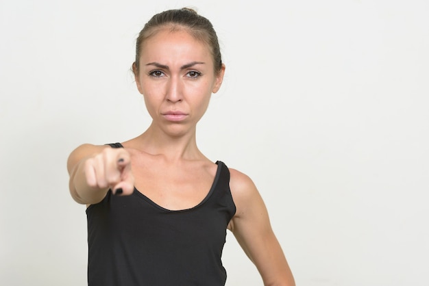 Sottolineato giovane donna con i capelli castani che punta alla telecamera