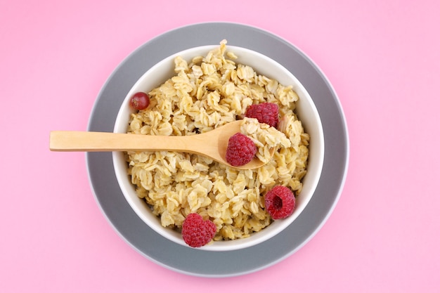 Sovraccarico di porridge su sfondo rosa