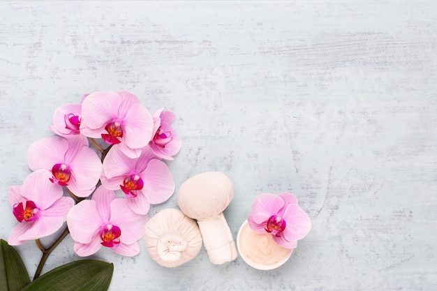 Spa aromaterapia sfondo, laici piatta di vari prodotti per la cura di bellezza decorati con semplici fiori di orchidea.