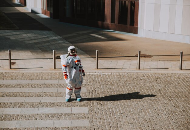 Spaceman in una stazione futuristica. astronauta con tuta spaziale che cammina in un'area urbana