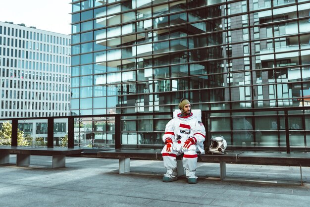 Spaceman in una stazione futuristica. astronauta con tuta spaziale che cammina in un'area urbana