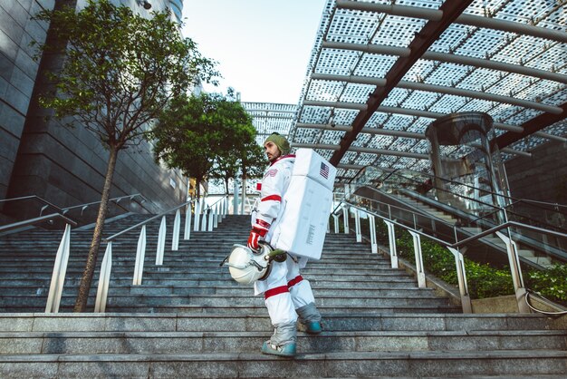 Spaceman in una stazione futuristica. Uomo con tuta spaziale che cammina in un'area urbana