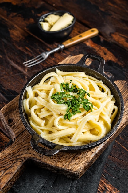 Spaetzle tedesco Tagliatelle all'uovo con burro e prezzemolo in una padella Fondo in legno Vista dall'alto