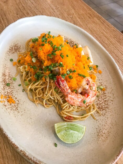 Spaghetti ad angolo saltati in padella con frutti di mare e uovo di gamberetti sul piatto