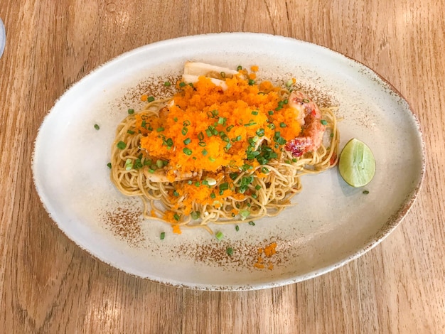 Spaghetti ad angolo saltati in padella con frutti di mare e uovo di gamberetti sul piatto