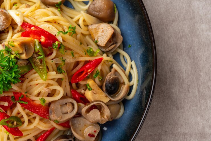 Foto spaghetti aglio e olio con aglio fritto, funghi, paprika, prezzemolo e peperoncino.