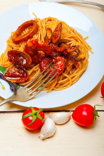 Spaghetti ai frutti di mare italiani su salsa di pomodoro rosso