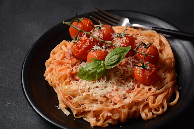 Spaghetti ai pomodorini guarniti con foglia di basilico