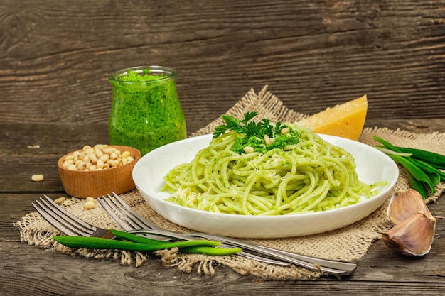 Spaghetti al pesto e foglie di aglio orsino fresco Posate parmigiano pinoli Stile rustico