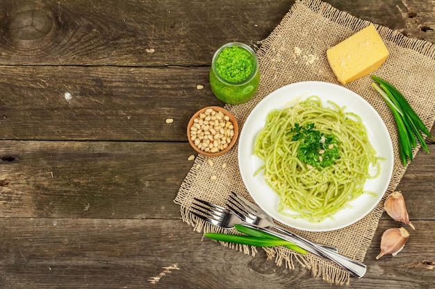 Spaghetti al pesto e foglie di aglio orsino fresco Posate parmigiano pinoli Stile rustico