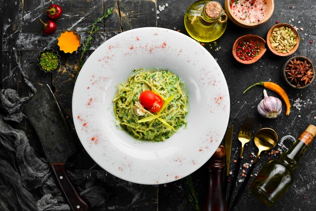 Spaghetti al pesto e parmigiano su un piatto bianco Vista dall'alto