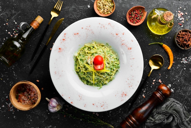 Spaghetti al pesto e parmigiano su un piatto bianco Vista dall'alto