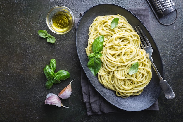 Spaghetti al pesto fatto in casa in un piatto nero, vista dall'alto