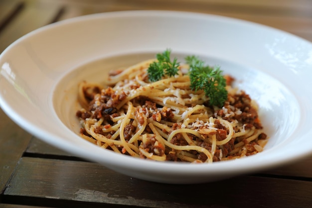 Spaghetti alla bolognese con carne macinata e salsa di pomodoro guarniti con parmigiano e basilico, cibo italiano