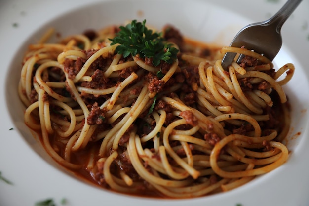 Spaghetti alla bolognese con salsa di pomodoro di manzo su tavola di legno, cibo italiano