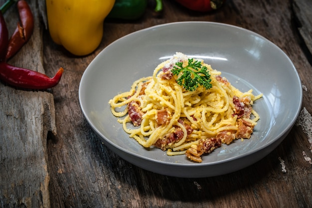 Spaghetti alla carbonara con pancetta su un tavolo di legno