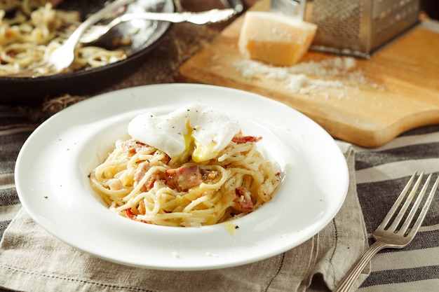 Spaghetti alla carbonara con uovo in camicia. Cibo italiano