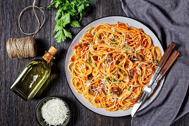 Spaghetti alla norma, classico piatto di pasta di melanzane saltate condite con salsa di pomodoro e condite con parmigiano grattugiato servito su un piatto, cucina italiana, vista orizzontale dall'alto, piatto