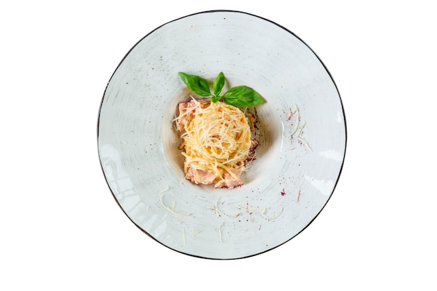 Spaghetti appetitosi con salsa di prosciutto e foglie di basilico Cibo italiano tradizionale Vista dall'alto Isolato su sfondo bianco