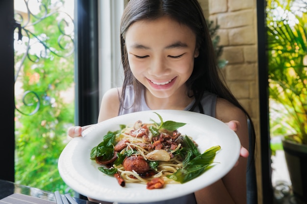 Spaghetti asiatici di esposizione della signora con la guarnizione tailandese dell'alimento