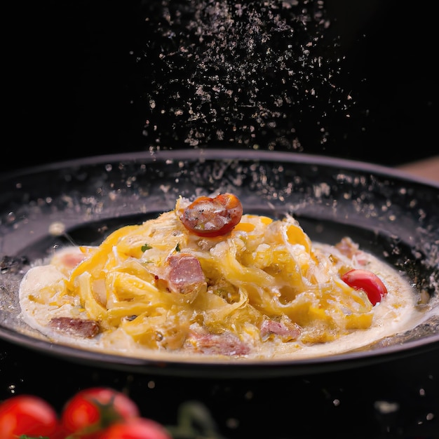 Spaghetti Carbonara prodotto girato, sfondo bokeh nero foto premium