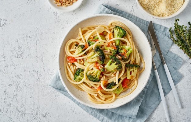 Spaghetti con broccoli, bucatini ai peperoni, aglio, pinoli. Cibo per vegani, vegetariani