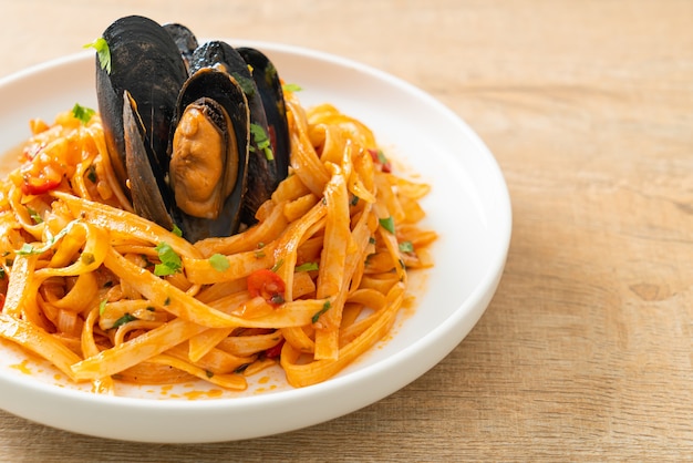 Spaghetti con cozze o vongole e salsa di pomodoro - Italian food style