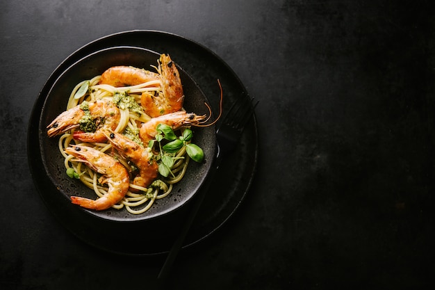 Spaghetti con pesto e gamberi serviti sul piatto