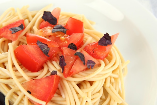 Spaghetti con pomodori e foglie di basilico alzato