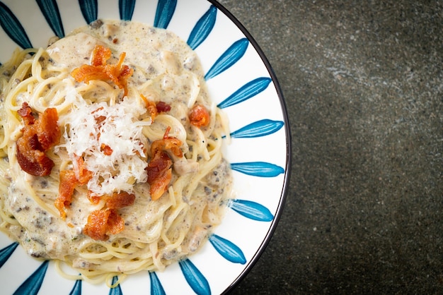 spaghetti con salsa di crema di tartufo e funghi sul piatto