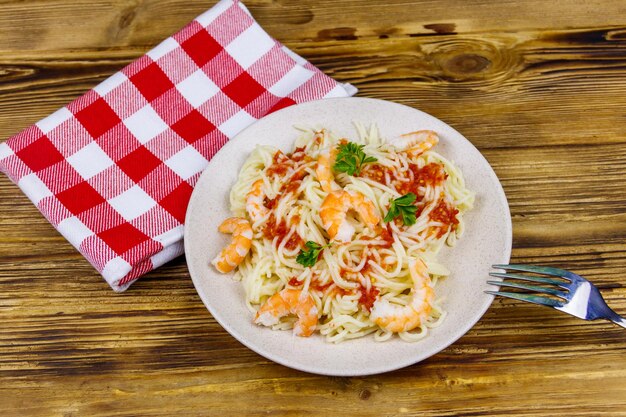 Spaghetti con salsa di pomodoro e prezzemolo gamberi sulla tavola di legno