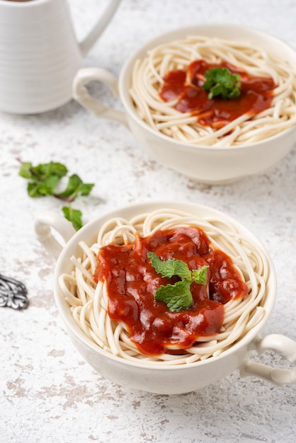 spaghetti con salsa di pomodoro su superficie bianca