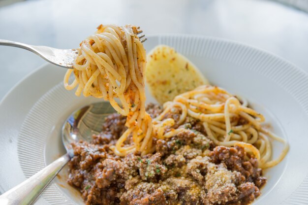 Spaghetti di carne in un piatto bianco