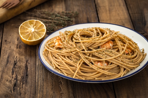 spaghetti di grano integrale con gamberi su legno