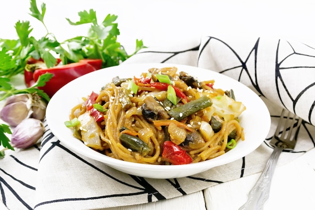 Spaghetti di grano saraceno con verdure in piatto a bordo