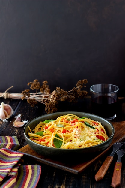 Spaghetti di pasta con pomodori, basilico e parmigiano. Cucina italiana. Ricetta. Mangiare sano.