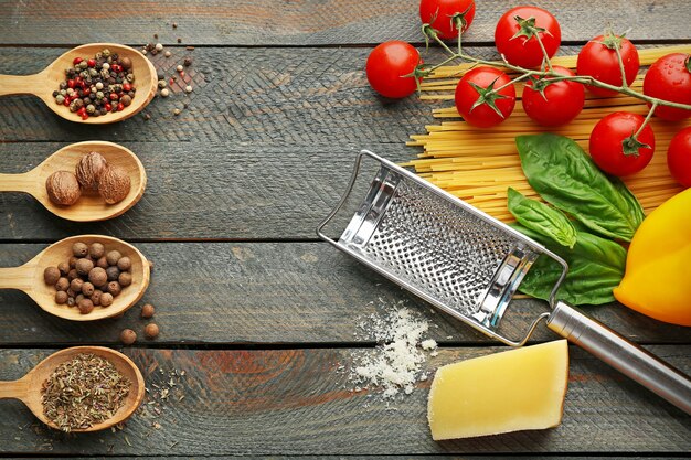 Spaghetti di pasta con pomodoro, formaggio e basilico su legno rustico