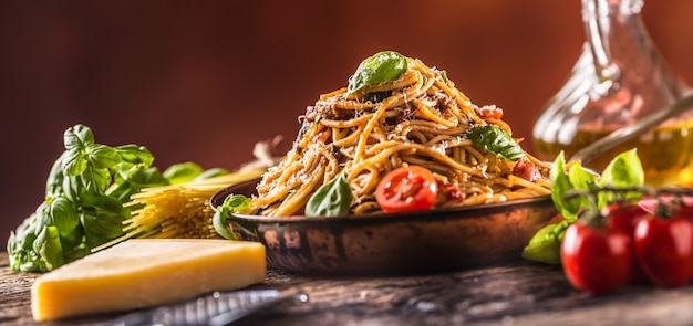 Spaghetti di pasta italiana con salsa di pomodoro olio d'oliva basilico e parmigiano nella vecchia padella.