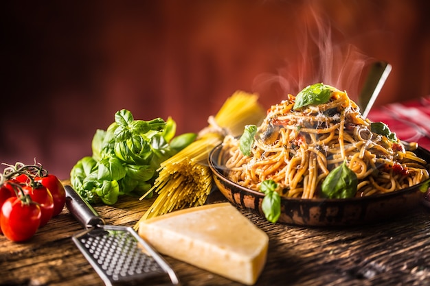 Spaghetti di pasta italiana con salsa di pomodoro olio d'oliva basilico e parmigiano nella vecchia padella.