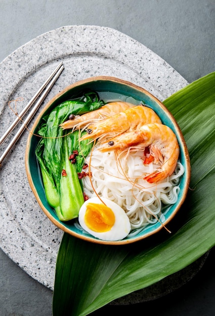 Spaghetti di riso asiatici con gamberi su sfondo grigio