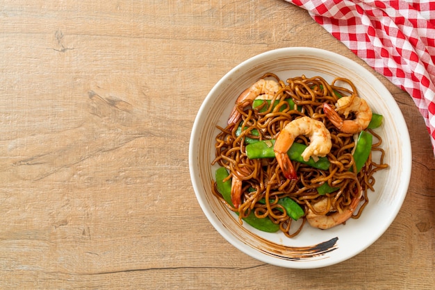 spaghetti di yakisoba saltati in padella con piselli e gamberetti - stile di cibo asiatico