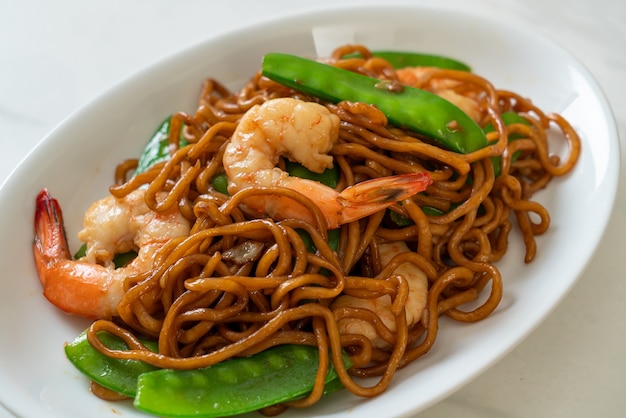 spaghetti di yakisoba saltati in padella con piselli e gamberetti - stile di cibo asiatico