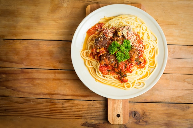 Spaghetti e polpette sulla tavola di legno.